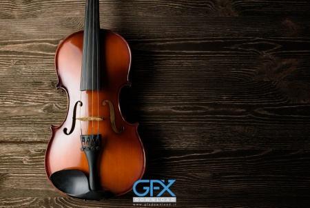 عکس ویولن قهوه‌ای براق روی پس‌زمینه تیره، مناسب چاپ تابلو موسیقی